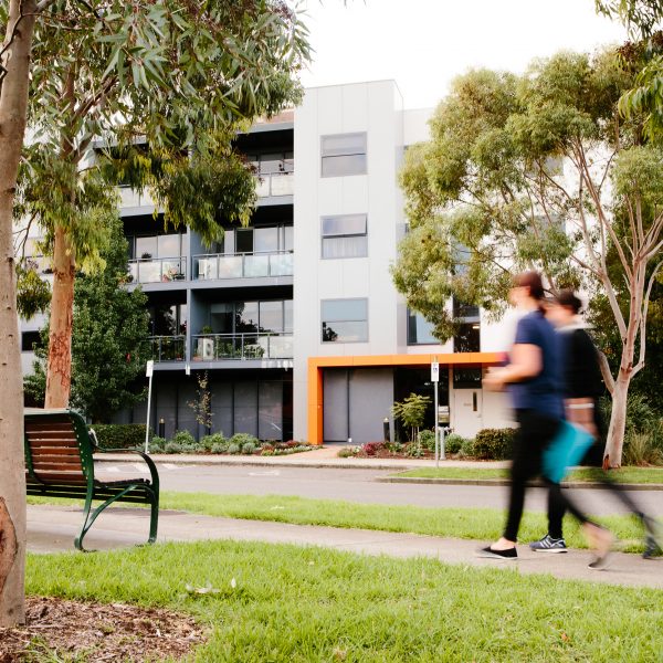 Exterior of Mercy Health Apartments Parkville and two women walking past
