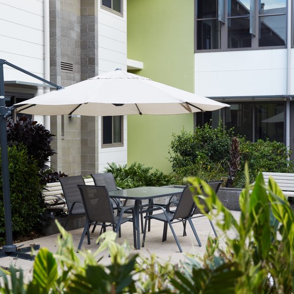 Patio with umbrella and chairs in outdoor area at Coral Sea Gardens