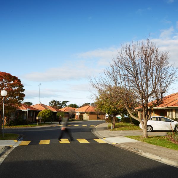 Units and a pedestrian crossing at Mercy Place Rice Village retirement on a sunny day