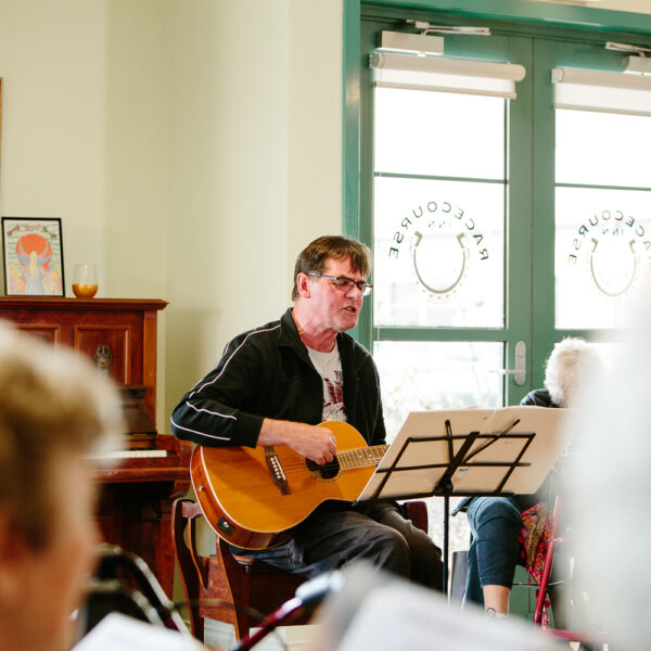 Man playing guitar for residents at Mercy Place Rice Village retirement