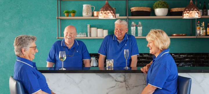 Four residents enjoying drinks in the community hub bar at Golden Rise retirement Bendigo